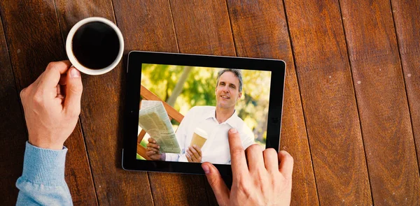 Verbundbild von Geschäftsmann mit Zeitung und Kaffeetasse im Park — Stockfoto