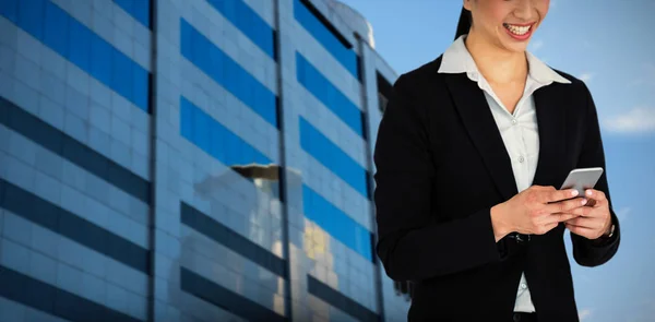 Imagen compuesta de una mujer de negocios sonriente sosteniendo un teléfono móvil — Foto de Stock