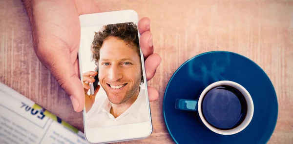 Zusammengesetztes Bild einer Person, die ihr Smartphone mit Kaffee und Dokument auf dem Tisch benutzt — Stockfoto