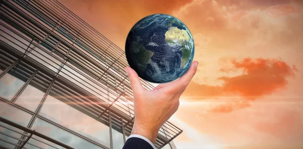 Composite image of businessman pointing little earth with his finger — Stock Photo, Image