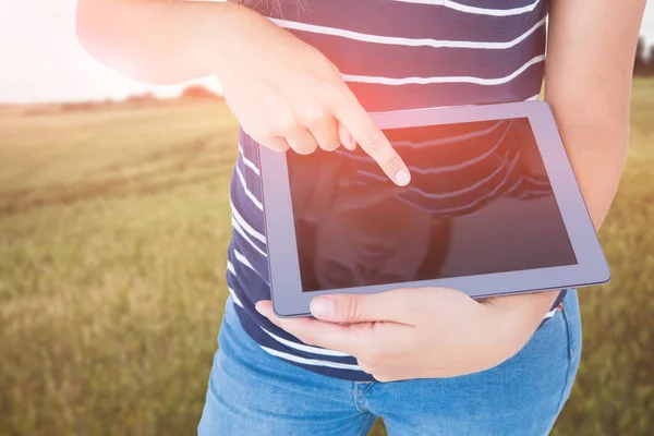 Sammansatta bilden av kvinnan som använder TabletPC mot landsbygdens landskap — Stockfoto