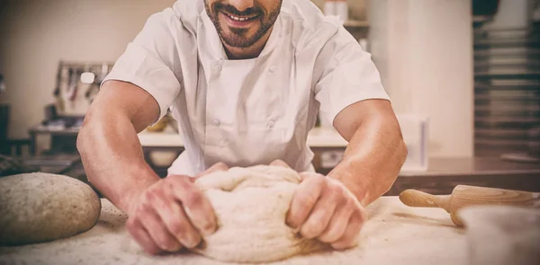 Baker amassando a massa de farinha em um balcão — Fotografia de Stock