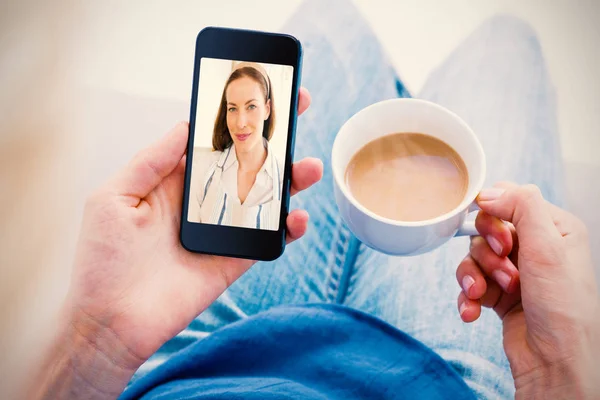 Imagem composta de mulher usando seu telefone celular e segurando xícara de café — Fotografia de Stock