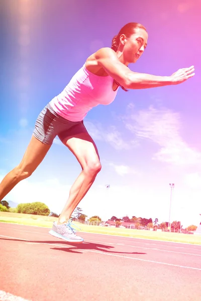 Atleta feminina correndo na pista de corrida — Fotografia de Stock