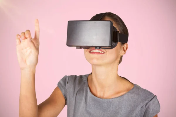 Zusammengesetztes Bild einer Frau, die mit einer Virtual-Reality-Brille zeigt — Stockfoto