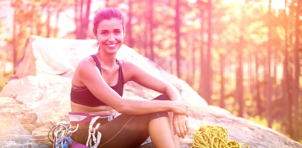 Mulher sorrindo e sentada com equipamento de escalada — Fotografia de Stock