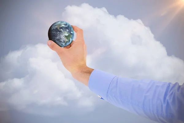Composite image of businessman holding little earth in presentation — Stock Photo, Image