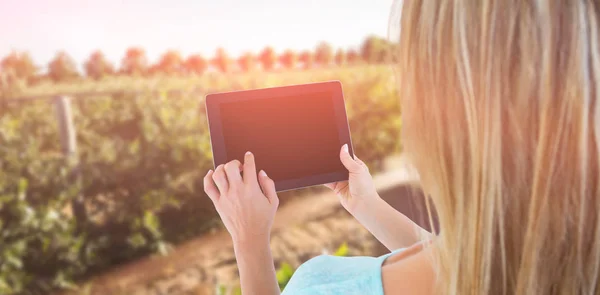 Kompositbild der Rückansicht einer Frau mit Tablet-PC — Stockfoto