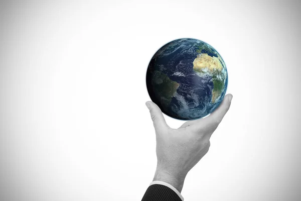 Composite image of businessman pointing little earth with his finger — Stock Photo, Image