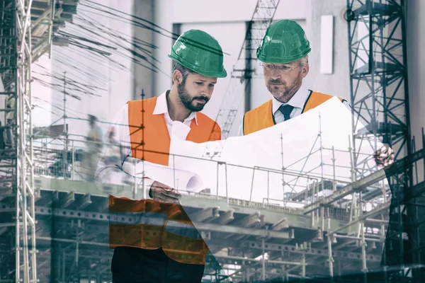 Homens que procuram planos para a construção de edifícios na cidade — Fotografia de Stock