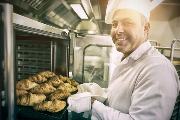 Mature baker smiling proudly at the camera — Stock Photo, Image