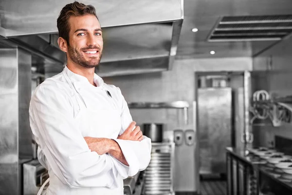 Smiling young chef standing with arms crossed Stock Photo