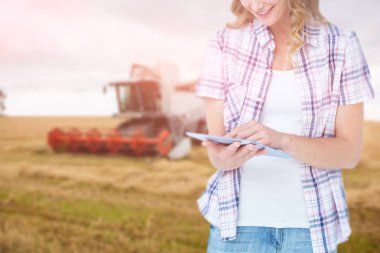 Composite image of pretty hipster using tablet against agricultural scene clipart