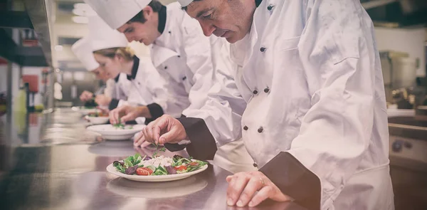 Köche bereiten ihre Salate zu — Stockfoto