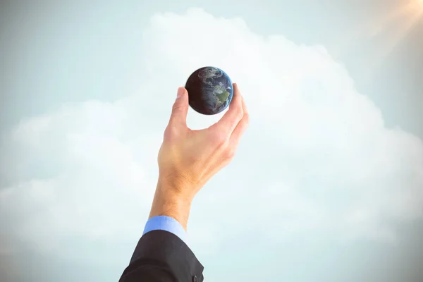 Composite image of businessman holding little earth in presentation — Stock Photo, Image