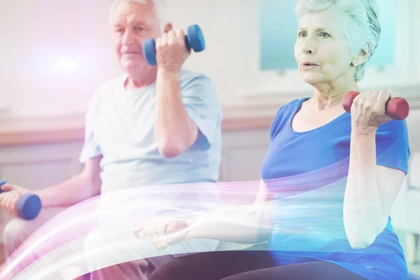 Senior couple lifting dumbbells — Stock Photo, Image