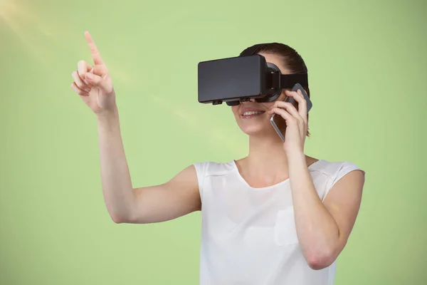 Imagem composta de mulher bonita gesticulando enquanto processa fone de ouvido realidade virtual e falando móvel — Fotografia de Stock