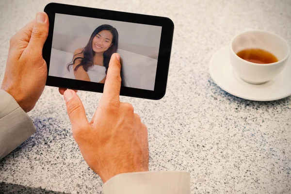 Samengestelde afbeelding van zakenman met behulp van kleine Tablet PC aan tafel — Stockfoto