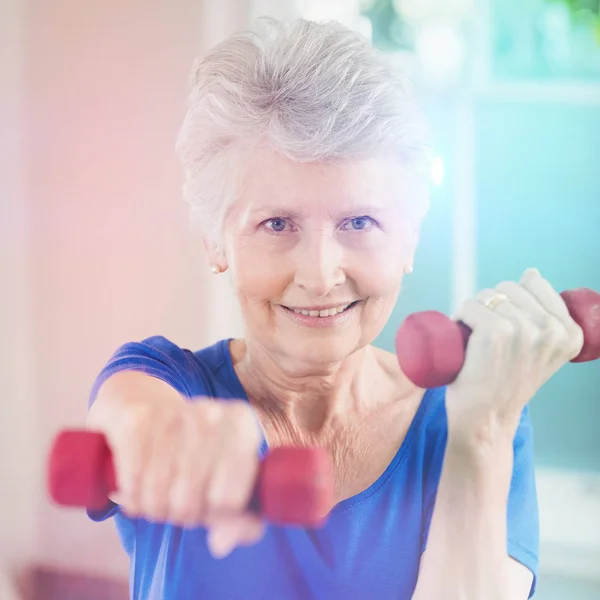 Portret van een oudere vrouw die traint met halters — Stockfoto