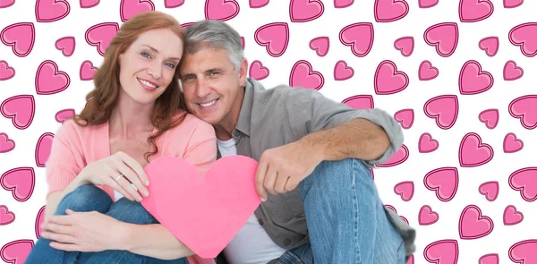 Casual couple holding pink heart — Stock Photo, Image