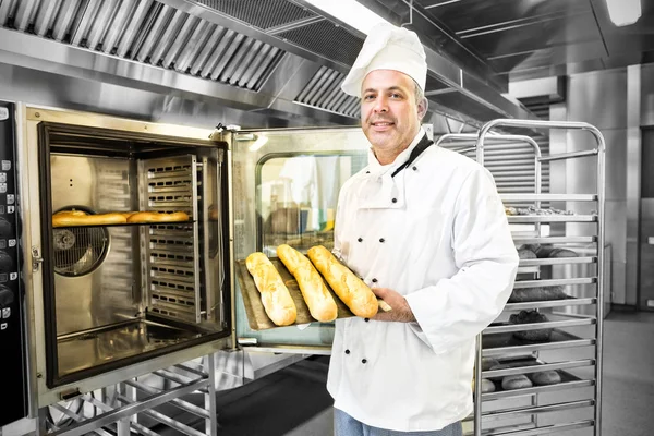 Orgulloso panadero maduro mostrando tres baguettes —  Fotos de Stock