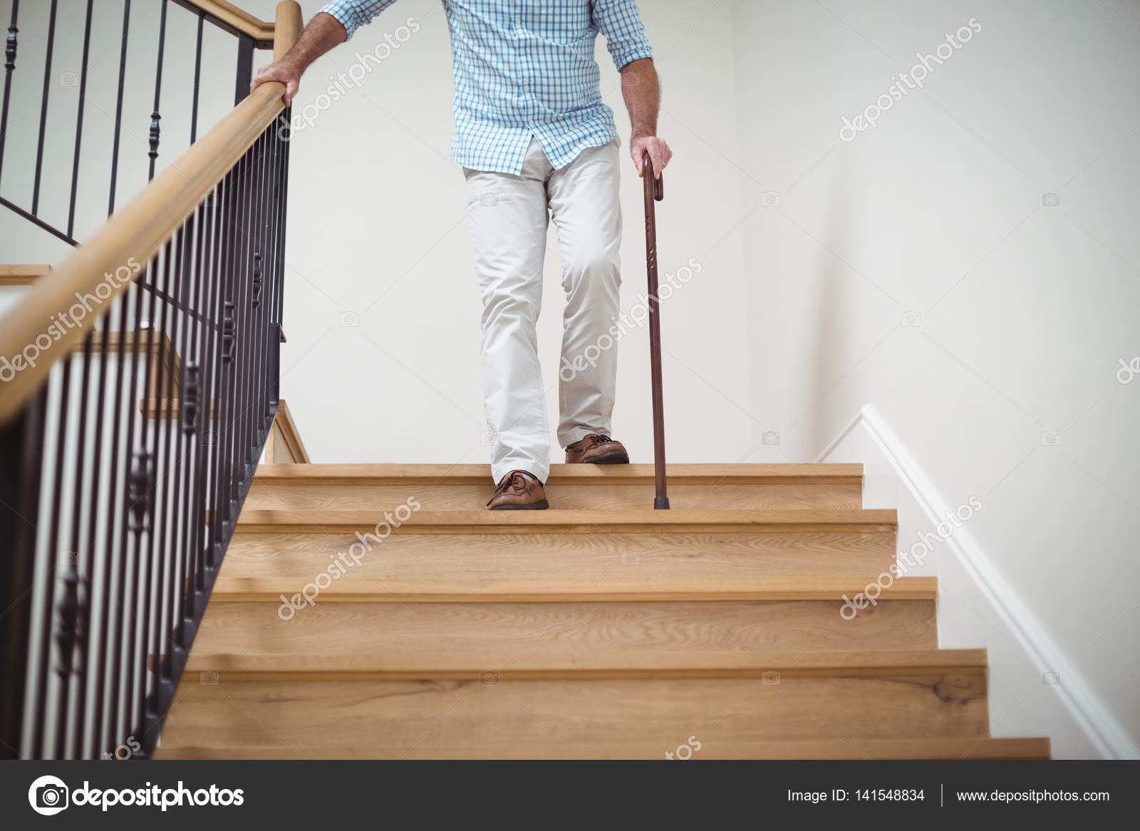 Senior man climbing downstairs with walking stick — Stock Photo