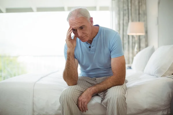 Pria senior stres duduk di tempat tidur — Stok Foto