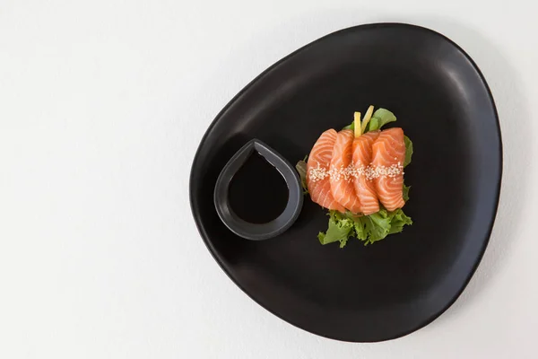 Quatro sushi sashimi servido com molho de soja em placa preta — Fotografia de Stock