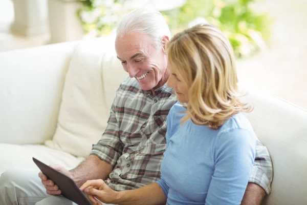 Coppia anziana che utilizza tablet digitale in soggiorno — Foto Stock