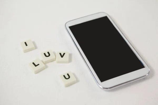 Teléfono móvil con bloques Te amo mensaje — Foto de Stock
