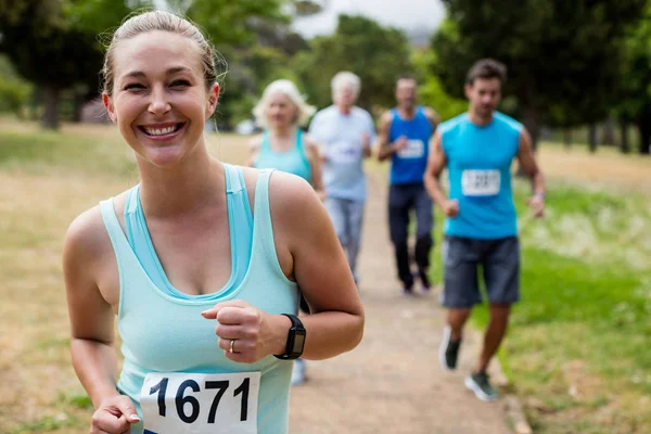 Athletes running race in park — Stock Photo, Image