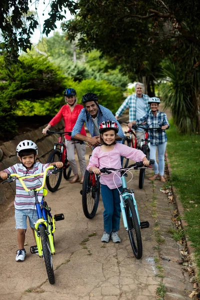 Портрет многодетной семьи, стоящей с велосипедом в парке — стоковое фото