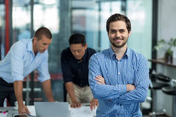 Business executive in piedi con le braccia incrociate in ufficio — Foto Stock