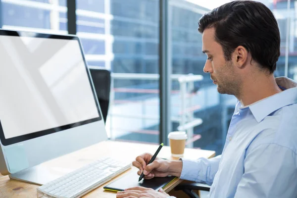 Male graphic designer using graphics tablet at desk — Stock Photo, Image