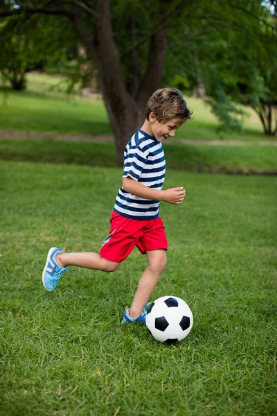 Chico jugando fútbol en parque — Foto de Stock