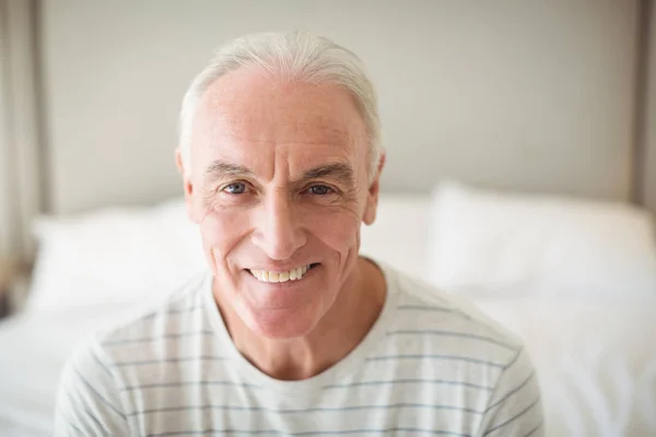 Portret van glimlachende man in slaapkamer — Stockfoto