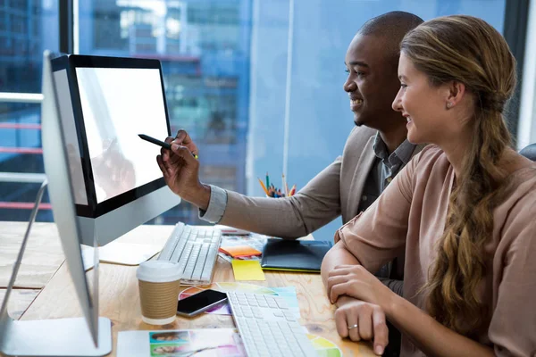 Graphic designer working at desk with colleague — Stock Photo, Image