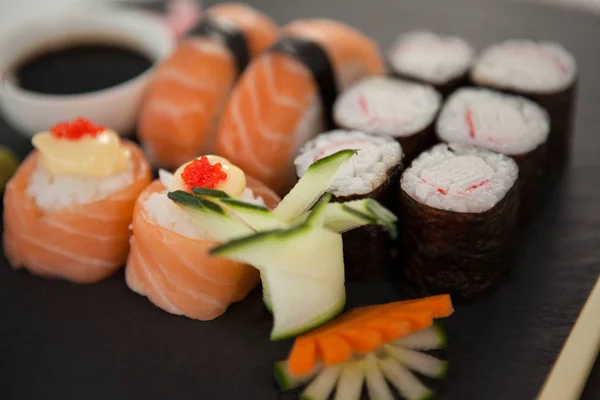 Uppsättning av blandade sushi serveras på svart sten skiffer med ätpinnar och sojasås — Stockfoto