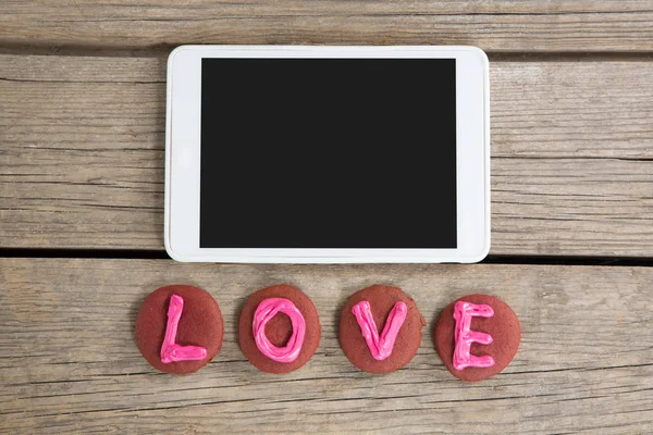 Digital tablet with cookies displaying love message — Stock Photo, Image