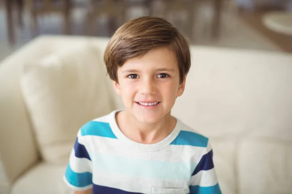 Portrait of boy standing near sofa in living room — Stock Photo, Image