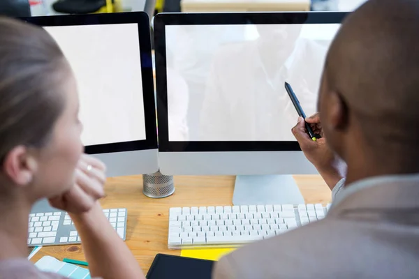 Designer gráfico trabalhando na mesa com colega — Fotografia de Stock