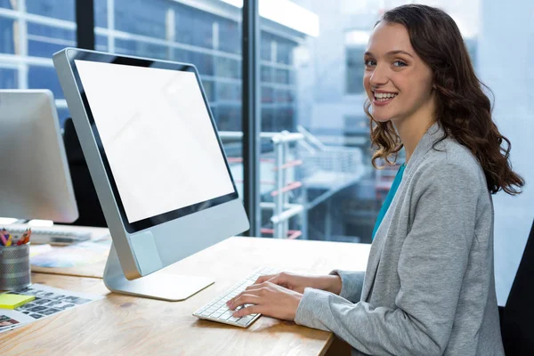 Женщина-графический дизайнер работает за компьютером за столом — стоковое фото