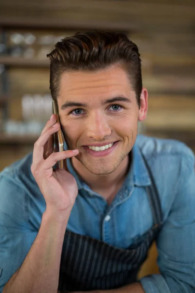 Portret kelner rozmowy na telefon komórkowy w kawiarni — Zdjęcie stockowe