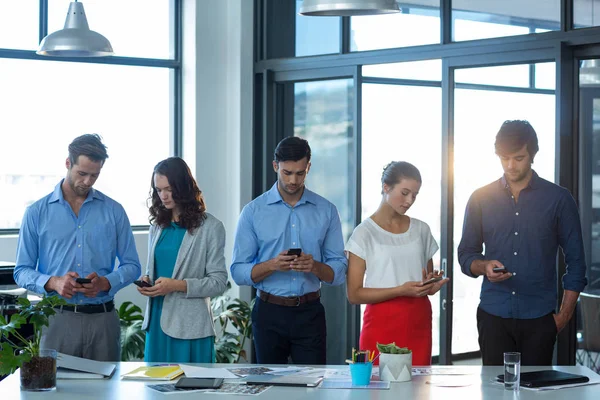 Team med grafiska formgivare med hjälp av mobiltelefon — Stockfoto