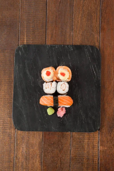 Sushi Nigiri i uramaki serwowane na czarny Łupek kamienny — Zdjęcie stockowe
