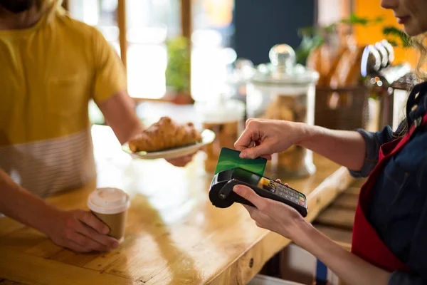 Pelanggan melakukan pembayaran melalui kartu kredit di konter di kafe — Stok Foto