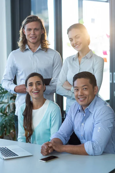 Retrato de empresarios sonrientes sentados en el escritorio —  Fotos de Stock