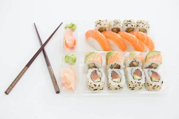 Prato de sushi nigiri e uramaki com pauzinho — Fotografia de Stock