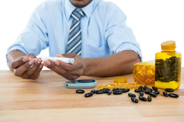 Businessman testing blood sugar with glucometer — Stock Photo, Image