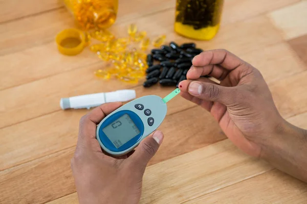 Mans hand testing blood sugar with glucometer — Stock Photo, Image